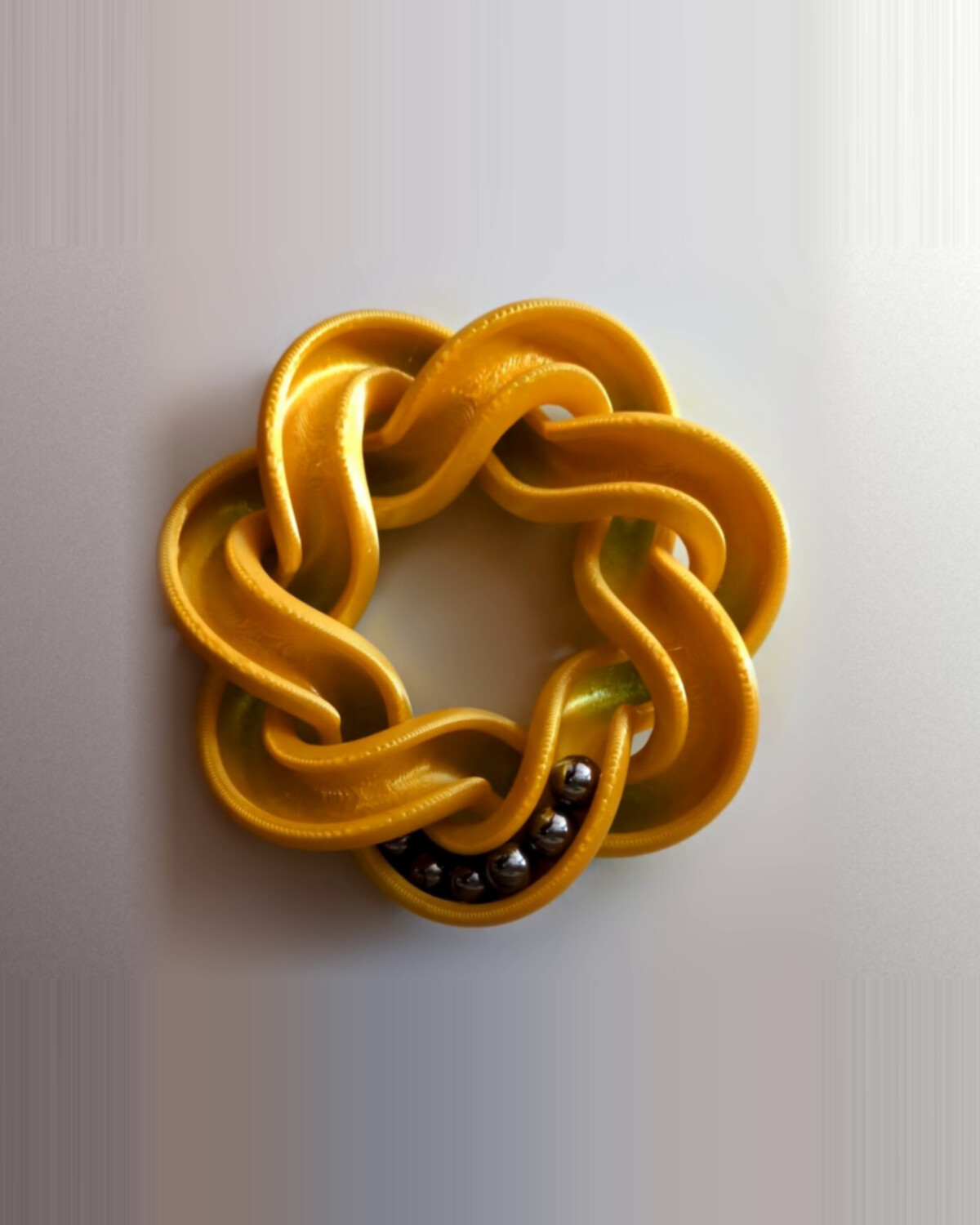 Septafoil marble track — a gold seven-lobed knot with steel balls inside
